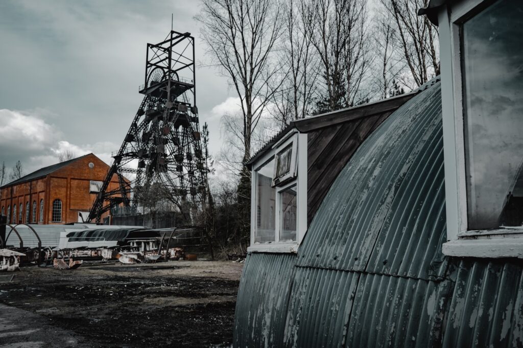 old colliery coal mine winding head, engine shed and railway equipment in the yard.