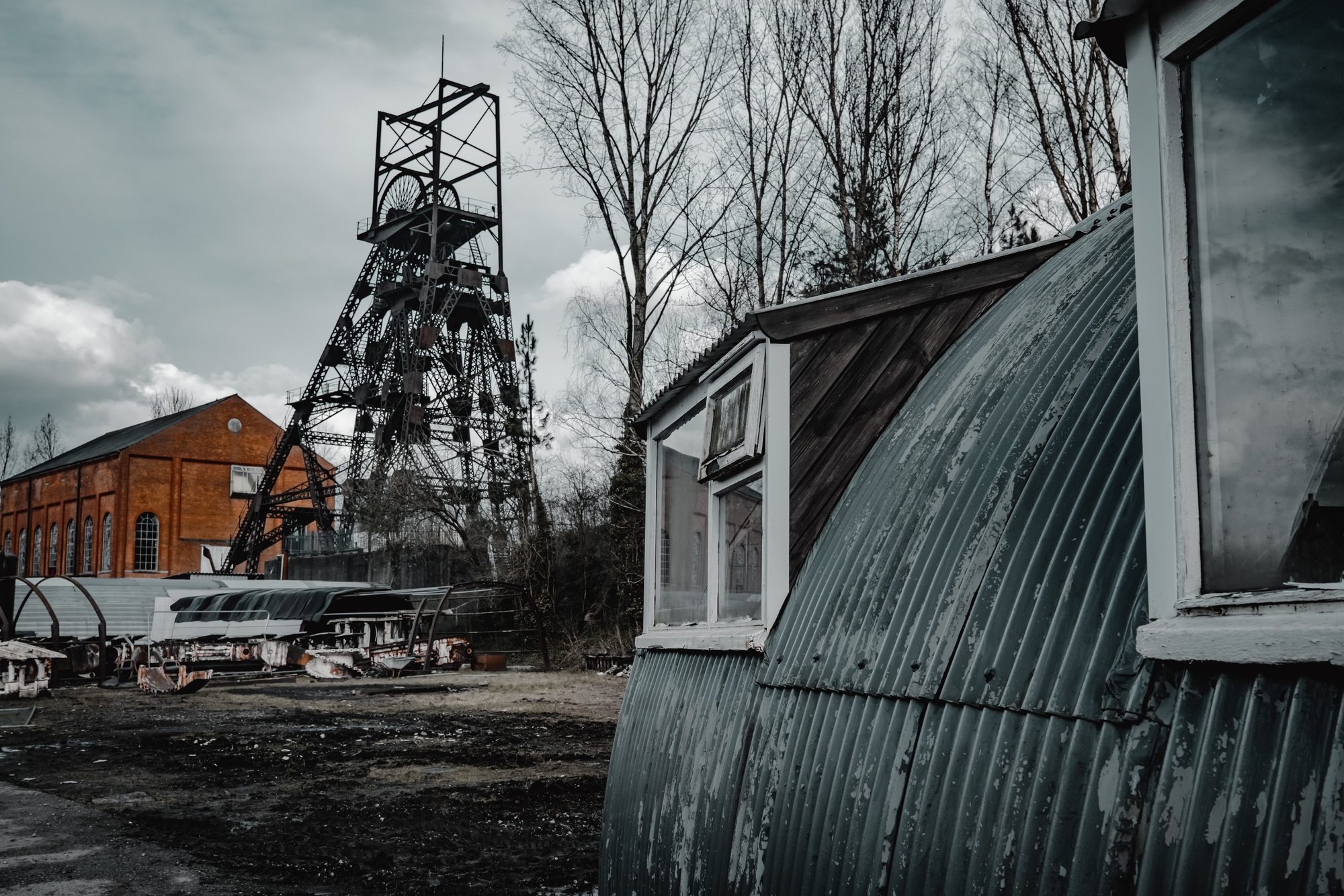 old colliery coal mine winding head, engine shed and railway equipment in the yard.